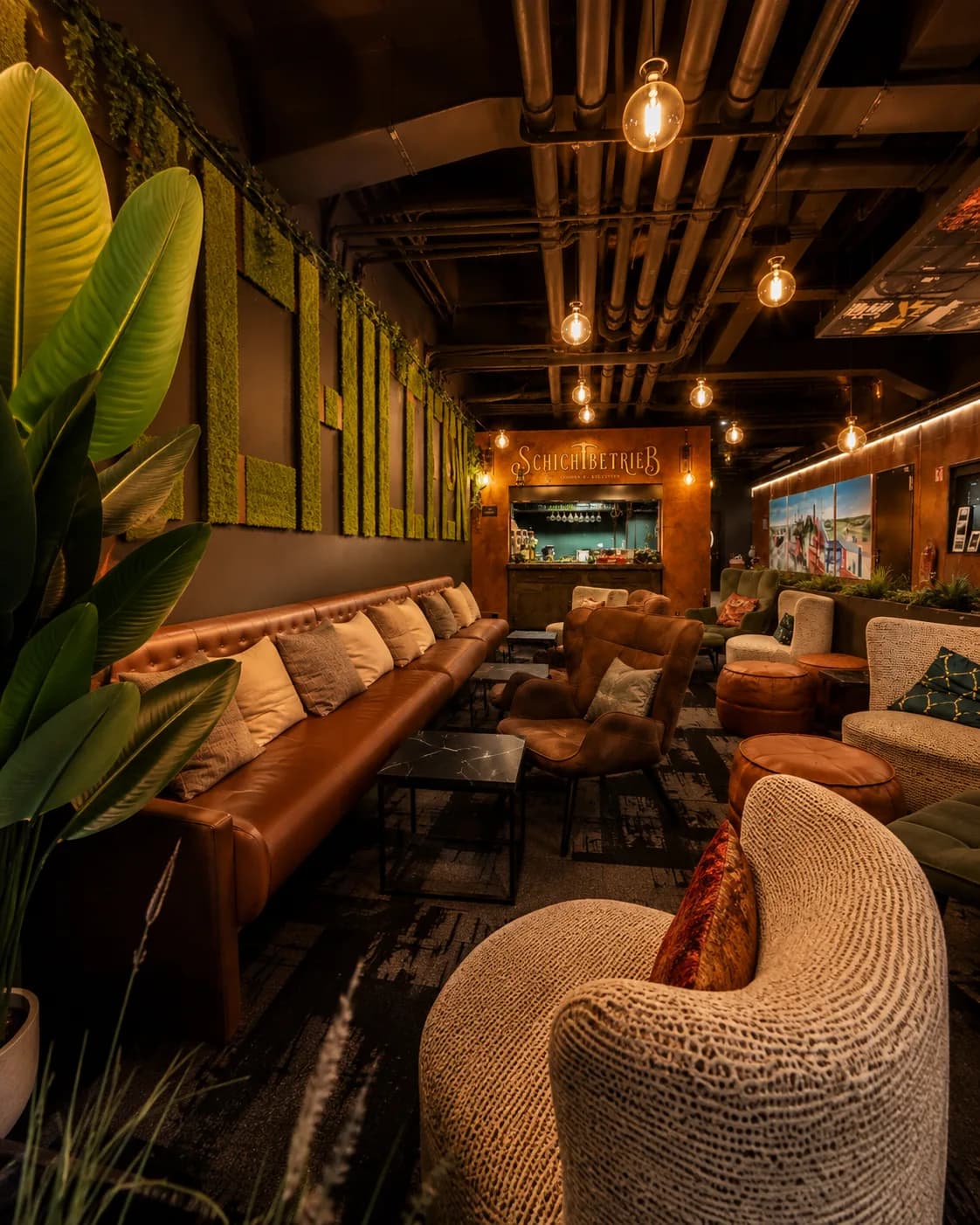 Blick durch die Lounge des Schichtbetriebs: Ledersofa, Mooswand und Grubenlampen